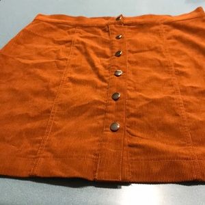 A orange skirt that has never been worn.